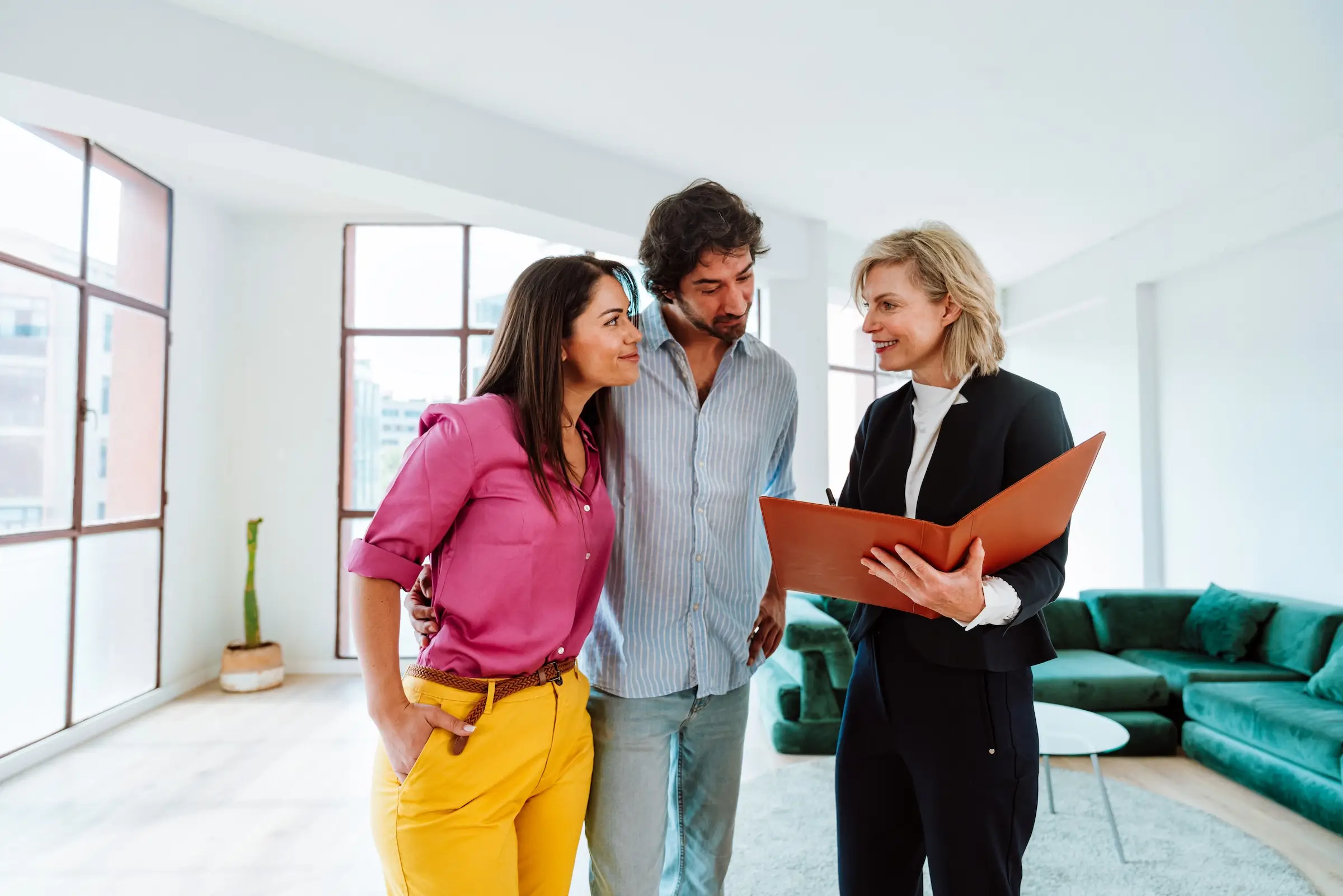 Agent immobilier faisant visiter un appartement à un couple
